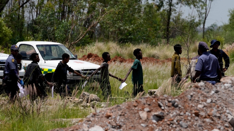 Rescuers bring out survivors and dead from a South African mine as hundreds remain trapped